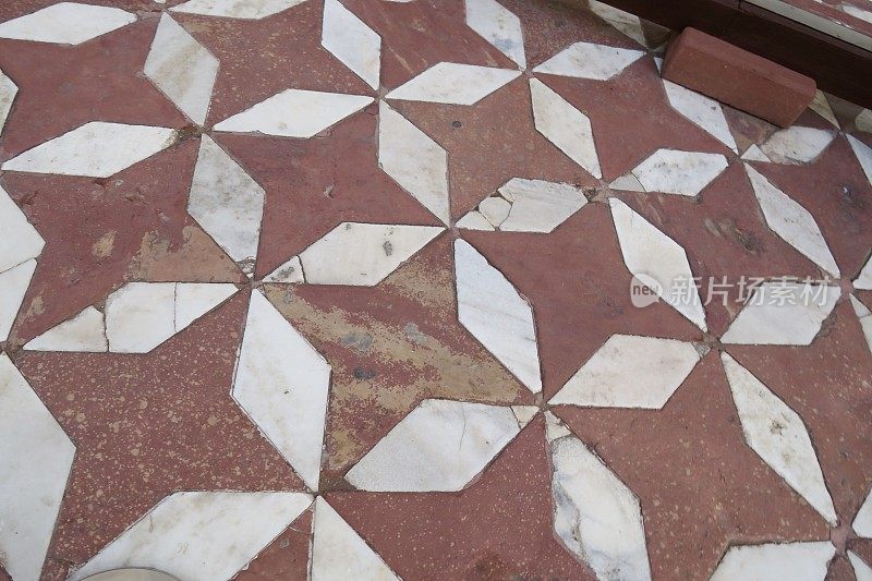 在印度阿格拉的泰姬陵附近，印度的八角形瓷砖地板与味精或镶嵌在红橙色粘土瓷砖形成几何图案和星形/八角形